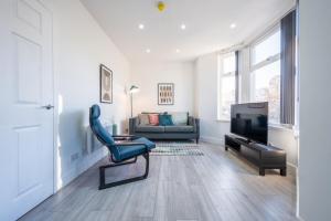 a living room with a couch and a television at Stylish 2 Bedroom - Church View 3 by Tŷ SA in Newport