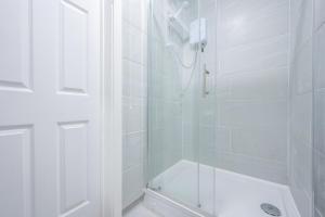 a white bathroom with a shower and a tub at Stylish 2 Bedroom - Church View 3 by Tŷ SA in Newport