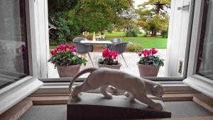 a statue of a dog standing in front of a window at Demeures ressourçantes - Le Vallon in Saint-Martin-de-Saint-Maixent +15 photos
