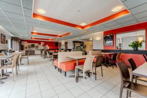 une salle à manger avec des tables et des chaises dans l'établissement Ace Hotel Arras-Beaurains, à Beaurains