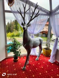 a statue of a deer standing in a window at Atrium Panoramic Hotel & Spa in Predeal