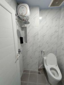 a white bathroom with a toilet and a shower at Horas Hotel in Sibolga