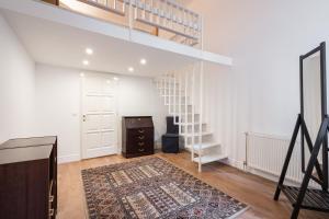 sala de estar con escalera y alfombra en Classical apartment with modern style downtown!, en Budapest