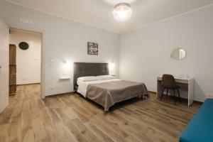 un dormitorio con una cama y un escritorio y una cama sidx sidx sidx en Sicily House Luxury, en Mazara del Vallo