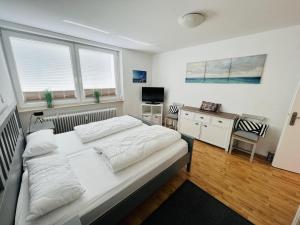 Schlafzimmer mit einem großen weißen Bett und einem Schreibtisch in der Unterkunft Hansastr. 1 W12 in Scharbeutz