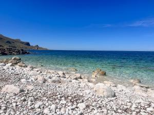a rocky beach with the water and sky at Rais in San Vito lo Capo +20 photos