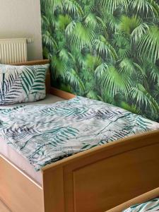1 cama en un dormitorio con papel pintado tropical en Fewo 1, en Gotha