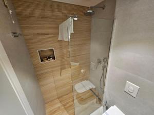 uma casa de banho com um chuveiro, um WC e um lavatório. em Hotel ETNA em Gračanica