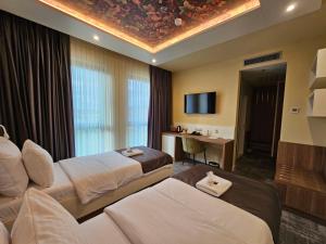 um quarto de hotel com duas camas e uma televisão em Hotel ETNA em Gračanica