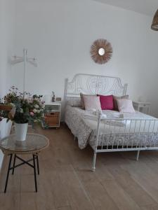 um quarto com uma cama branca e almofadas cor-de-rosa em Casa dei Sette Nani em San Giovanni Suergiu