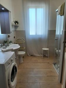 uma casa de banho com um lavatório e uma máquina de lavar roupa em Casa dei Sette Nani em San Giovanni Suergiu