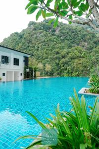 een zwembad met een berg op de achtergrond bij JOMSTAY Sunway Onsen Suites Ipoh - Lost World of Tambun Ipoh Waterpark in Tambun