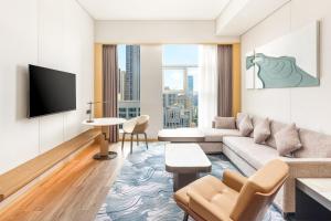 a living room with a couch and a tv at The Westin Wuhan Hanyang in Wuhan