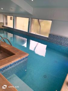 uma grande piscina com água azul e janelas em Atrium Panoramic Hotel & Spa em Predeal