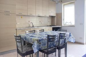 een keuken met een tafel met stoelen en een wastafel bij Casa Rosa sul Mare in Capo dʼOrlando
