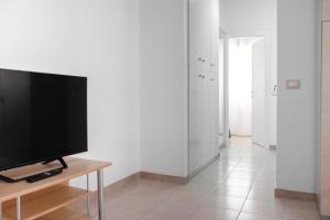 een woonkamer met een flatscreen-tv op een tafel bij Casa Rosa sul Mare in Capo dʼOrlando