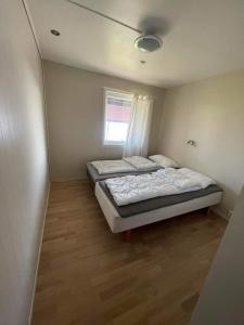 1 Schlafzimmer mit 2 Betten und einem Fenster in der Unterkunft Nautnes Brygge in Nautnes