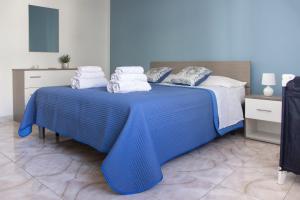 a blue bed with white towels on top of it at Casa Rosa sul Mare in Capo dʼOrlando