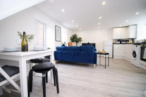 a living room with a blue couch and a table at The White House by Tŷ SA - Zip World & Bike Park in Aberdare