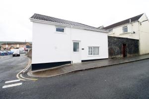 a white building on the side of a street at The White House by Tŷ SA - Zip World & Bike Park in Aberdare