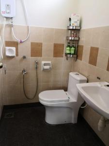 een badkamer met een douche, een toilet en een wastafel bij Garden Homestay in Kulai
