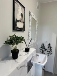 een witte badkamer met een wastafel en een spiegel bij Szumi Las Bed & Breakfast in Józefów