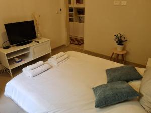 um quarto com uma grande cama branca e 2 toalhas em A Spot on the Hill em Umm el Shuf
