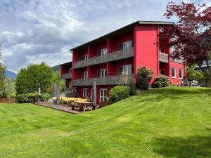 a red building with a picnic table in front of it at Fewo Löwenherz in Seeboden