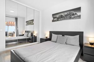 Un dormitorio con una cama grande y un espejo grande. en Holiday relax apartment, en Adeje
