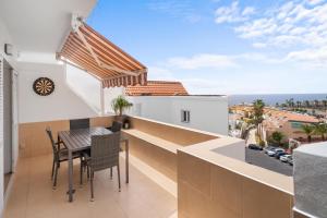 Un balcón con una mesa y sillas en un edificio. en Holiday relax apartment, en Adeje