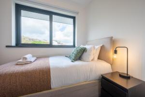 een slaapkamer met een bed en een raam bij Trinity View by Tŷ SA - Beautiful 5 bed in Newport in Caerleon