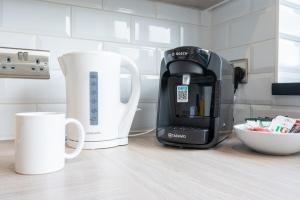 a coffee maker and coffee cups on a kitchen counter at Trinity View by Tŷ SA - Beautiful 5 bed in Newport in Caerleon