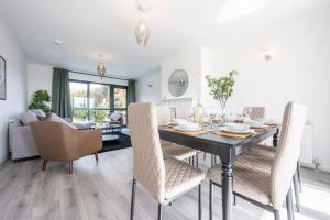 a dining room and living room with a table and chairs at Trinity View by Tŷ SA - Beautiful 5 bed in Newport in Caerleon