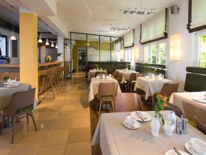 un restaurant avec tables et chaises et nappes blanches dans l'établissement ACHAT Hotel Regensburg Herzog am Dom, à Ratisbonne