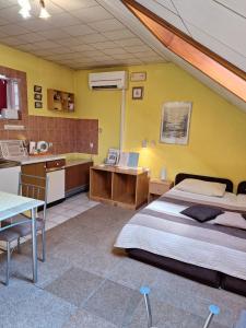 1 dormitorio con 1 cama, cocina y mesa en Apartmani Ivančica en Varaždin