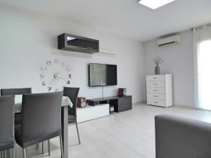 a white living room with a table and a television at Tu oasis, a la orilla del mar in Salou