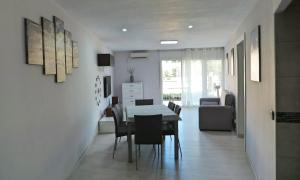 a dining room and living room with a table and chairs at Tu oasis, a la orilla del mar in Salou