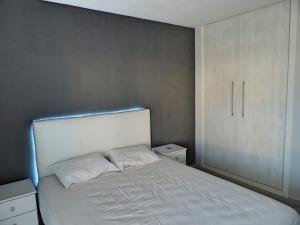 a bedroom with a white bed and a white cabinet at Tu oasis, a la orilla del mar in Salou