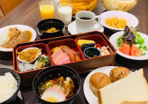 una mesa con tazones de comida y platos de comida en APA Hotel Nagoya Sakaeekimae Excellent, en Nagoya