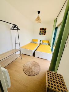 Cette chambre comprend 2 lits et une fenêtre. dans l'établissement Evasion tropicale, à Bretteville-sur-Odon