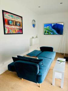 un soggiorno con divano blu e tavolo di Evasion tropicale a Bretteville-sur-Odon