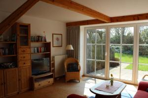 een woonkamer met een tv en een groot raam bij Ferienhof " Dat grode Gulfhuus" in Tossens