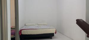 un piccolo letto con due asciugamani sopra in una stanza di MAIDEEN HOMESTAY CAMERON HIGHLANDS a Brinchang