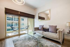 a living room with a couch and a glass table at Renovated 1 Bed Al Alka 1 In The Greens in Dubai