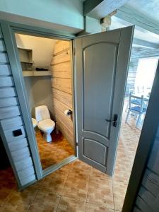 an open door to a bathroom with a toilet at Two lakes villas&camps in Markutiškės