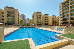una grande piscina con sedie e edifici di Renovated 1 Bed Al Alka 1 In The Greens a Dubai