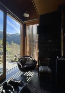 ParadinhaにあるCasa da Azenha - Aldeia da Paradinha com praia fluvialの大きな窓のある部屋(椅子付)