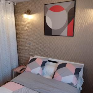 a bedroom with a bed with a picture on the wall at Chambre privée-Clim-TV-Confort-Breakfast inclus in Nevers