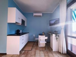 cocina con paredes azules, mesa y sillas en Bellagio Panoramic Mini Loft Giove en Bellagio