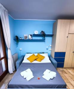 Habitación azul con cama con almohadas amarillas en Bellagio Panoramic Mini Loft Giove en Bellagio